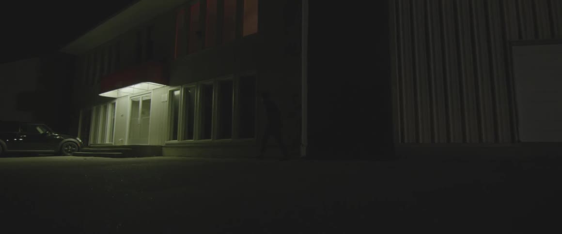 A man runs out of the shadows and attempts to break in to a building