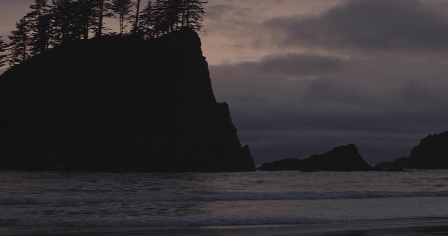 Water waves hit the beach at sunset