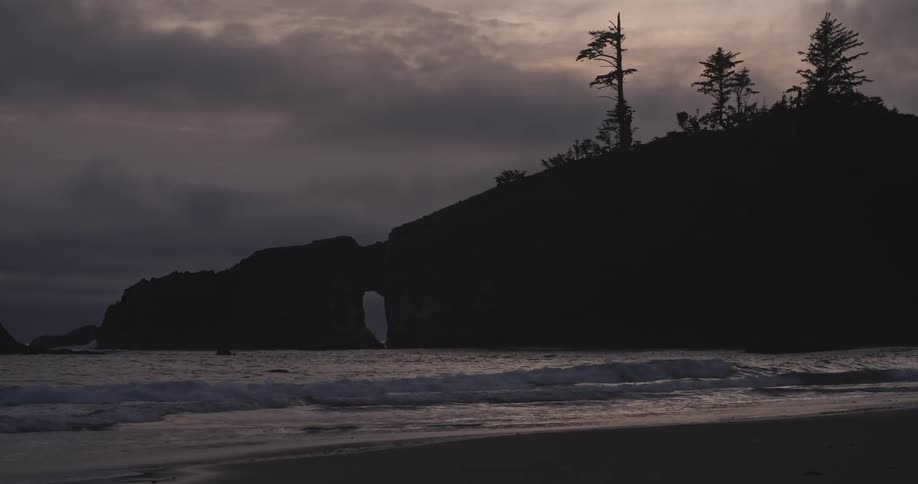The ocean tide coming in on a beach at sunset