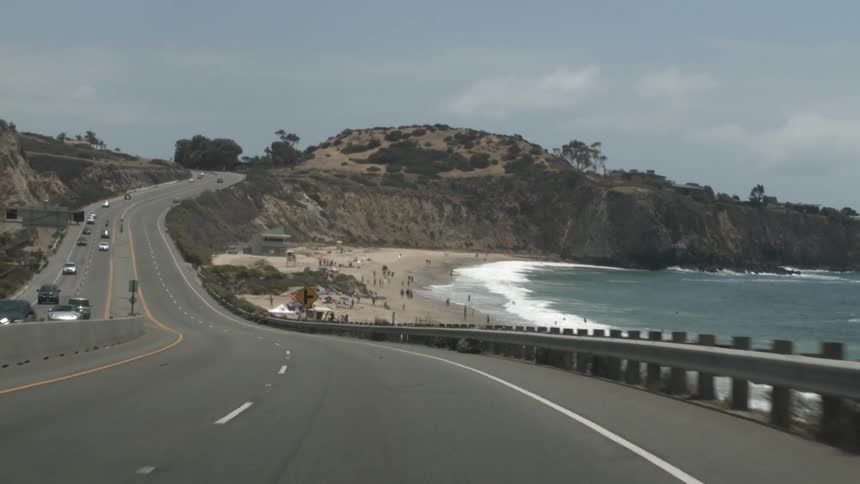 Cars drive down a coast highway