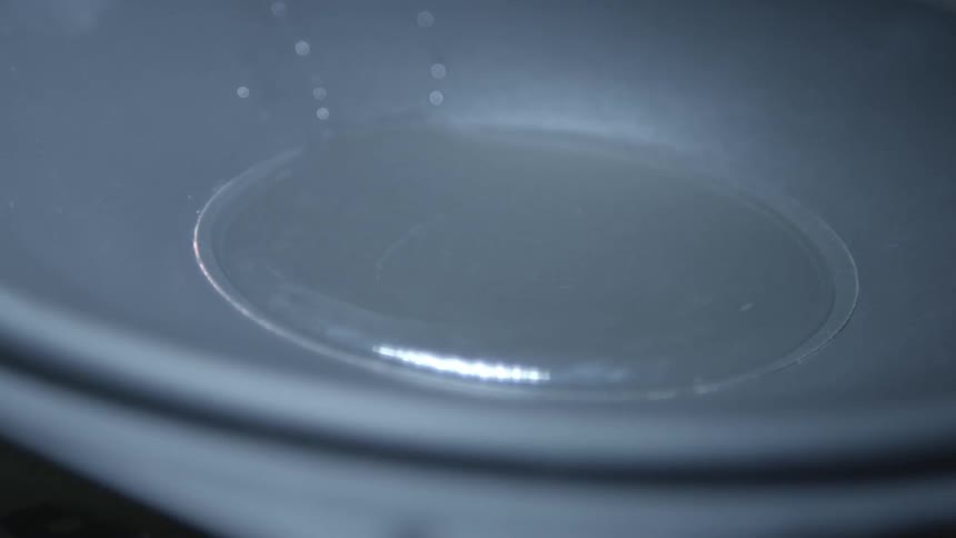 Liquid being poured into a shallow, bowl-shaped container