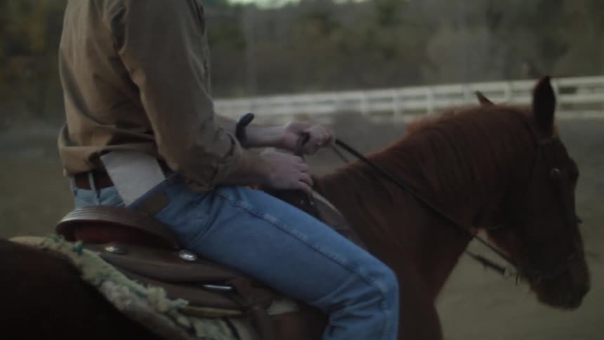 A man sits in a saddle on a horse