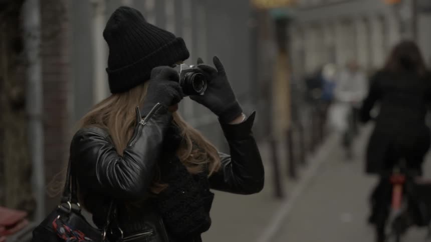 Woman taking pictures in a city on a cold day