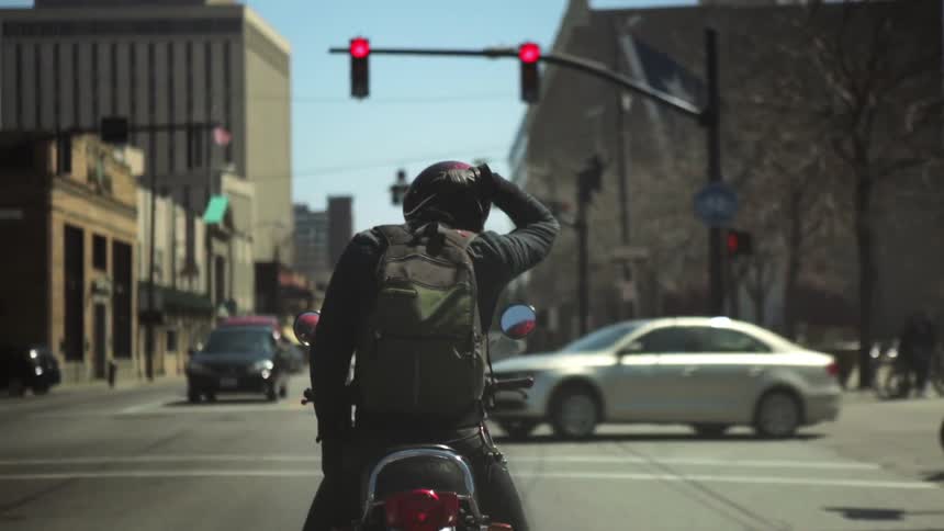 A person riding a motorcycle at a  stoplight