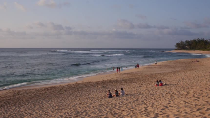 People sitting on a beach on a sunny day