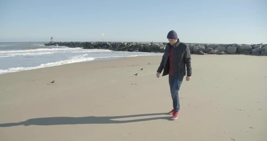 A man walks down a beach