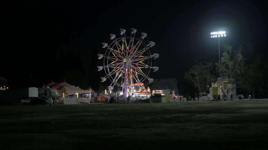 A ferris wheel lights up against a dark, night sky