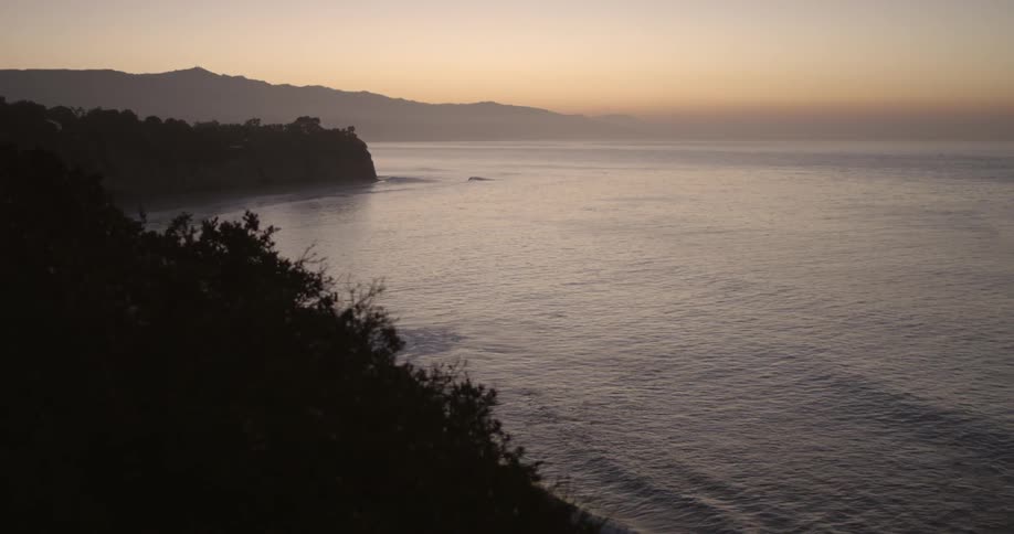 Waves lap onto the beach at sunset