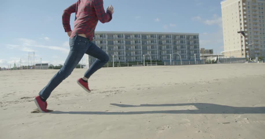 A man runs along the beach