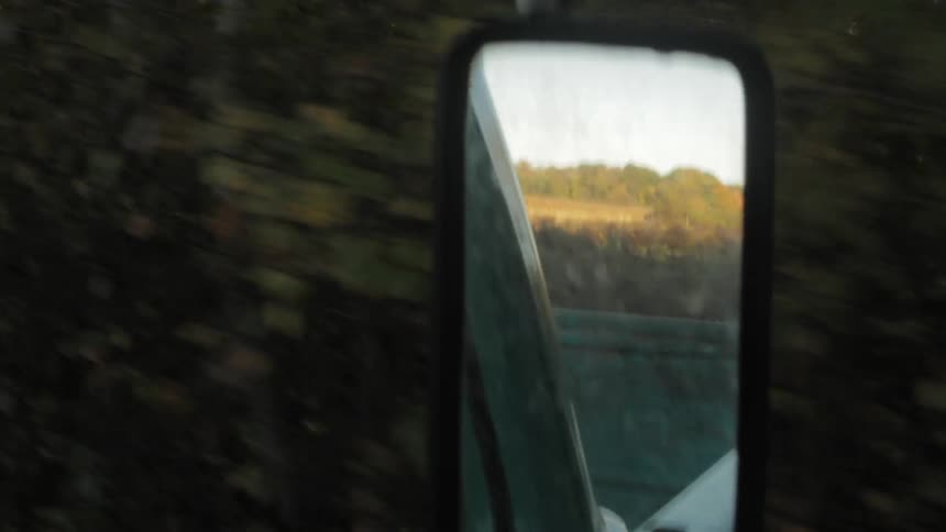 View out the window of a truck driving down a road