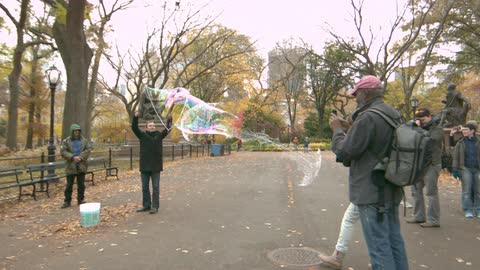 People are blowing bubbles in a park