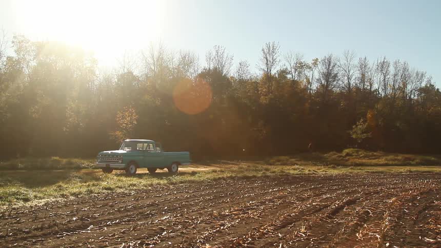 A vintage car parked in the rural area at dawn