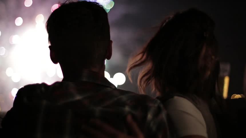 A couple of people enjoying a fireworks show