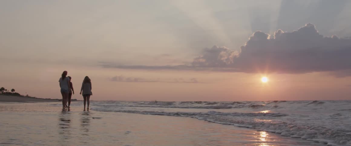 A group of people walking on the beach