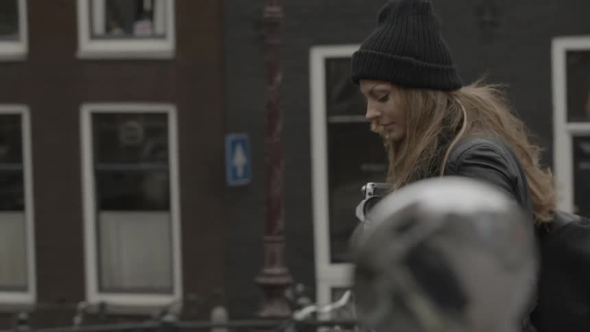 A woman in the city holds a camera