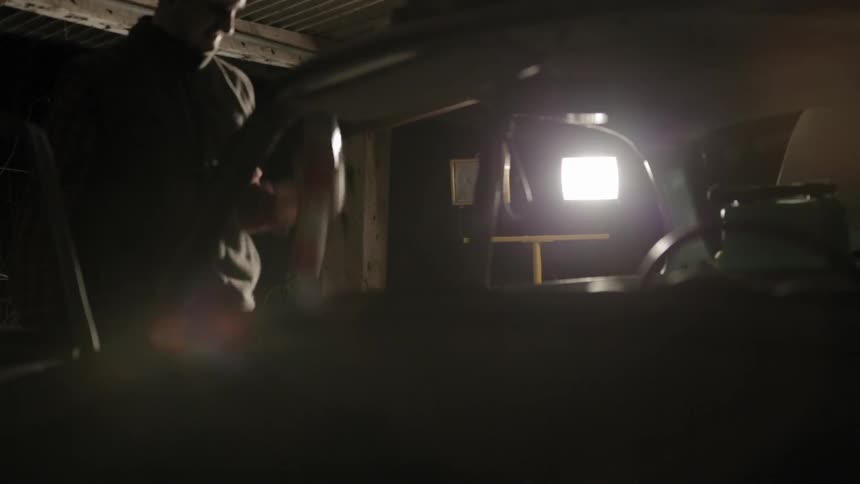 Man shaking a can of spray paint next to a car