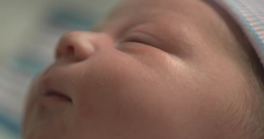 A newborn baby starts to open its eyes