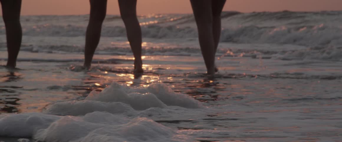 A group of people walking on the beach