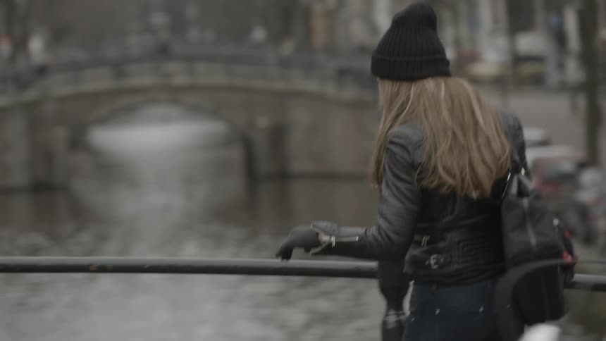 Woman taking pictures of a city waterway