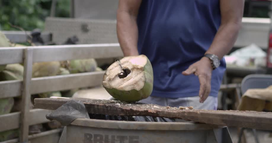 A man slicing into a tough fruit