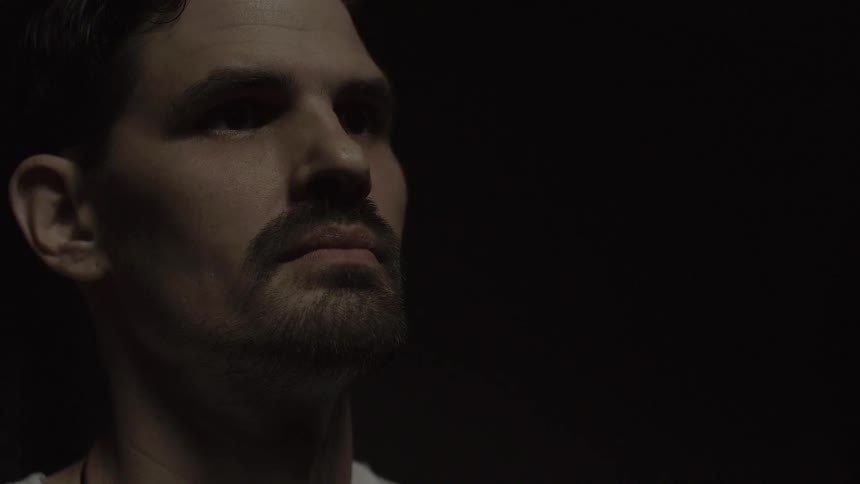 Man stands in a dark room contemplating
