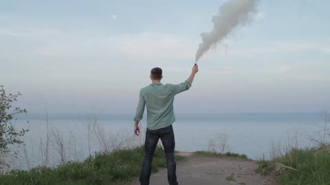 A man is holding a smoke flare