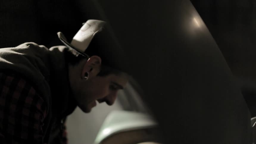 Man wearing a cap is talking to himself while working