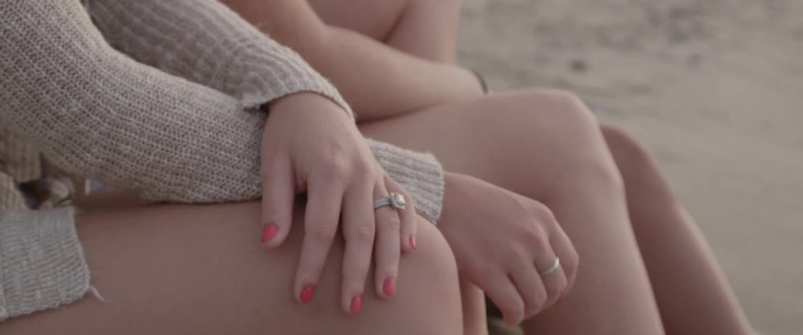 Two women sitting on a beach