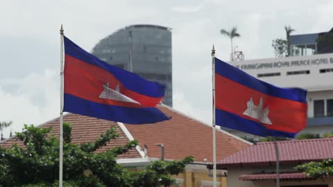 Flags waving in the wind outside some buildings