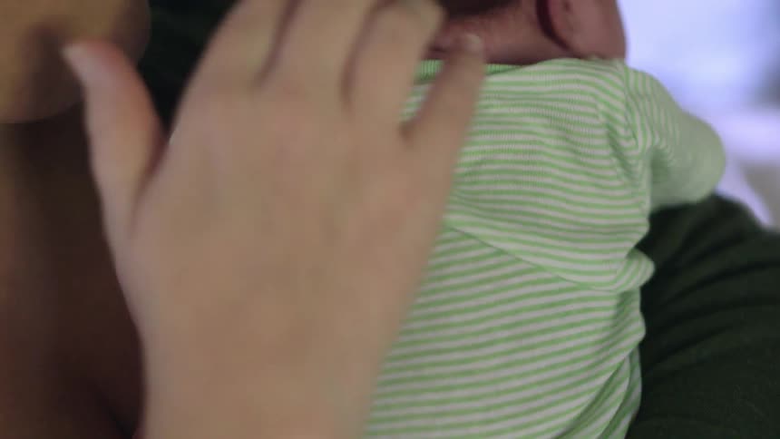 Mother patting her newborn baby on the back