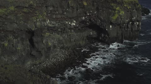 Waves crashing on a rocky cliff side