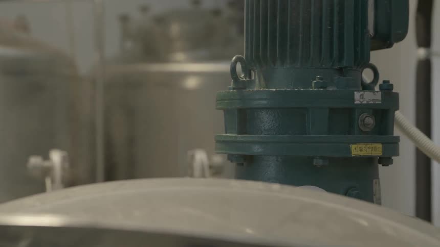 A steaming vat among other vats and pipes