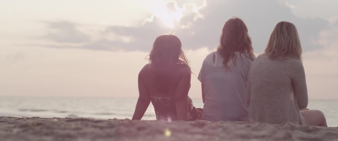 A group of people sitting on the beach