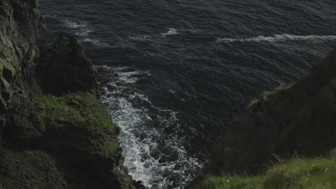 Edge of a rocky and grassy cliff overlooking the ocean
