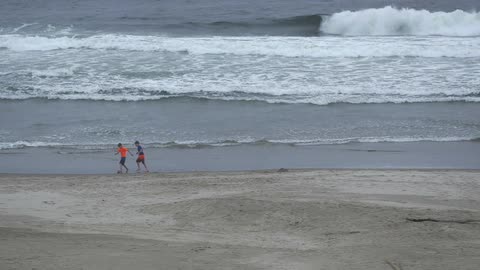 Two children kicking a ball on the beach