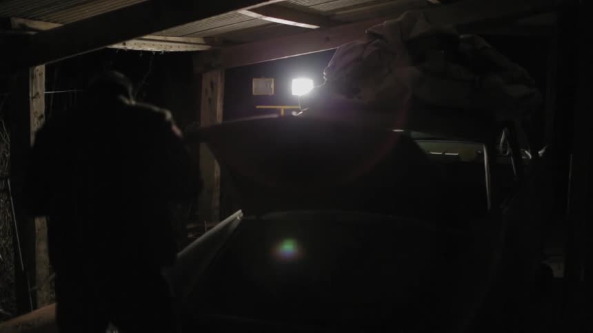 A man looks under the hood of a car