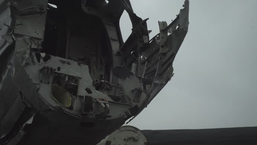 Navy airplane wreckage sitting in a field on an overcast day