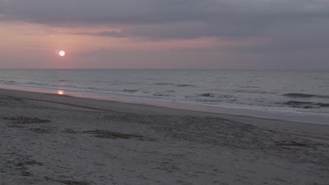 Waves crashing onto shore at sunset