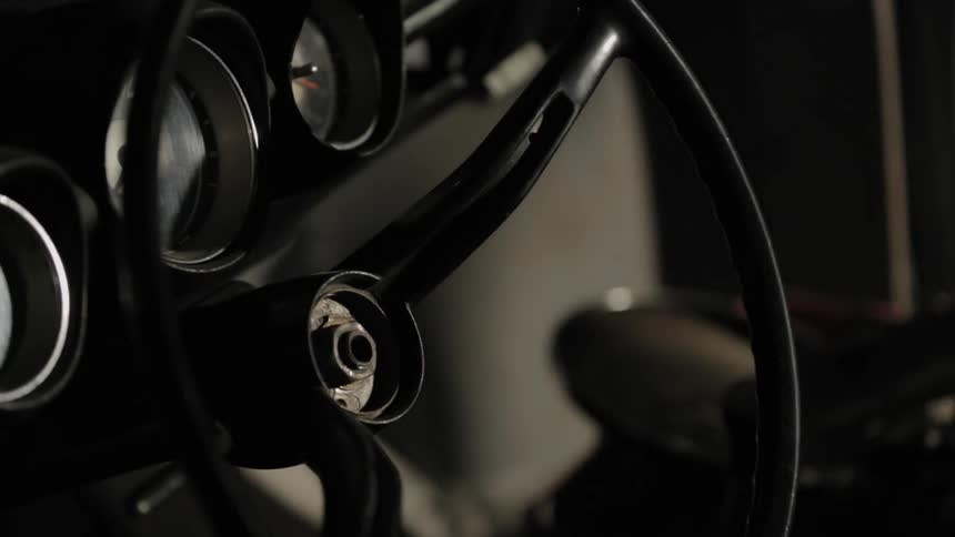 A torn down steering wheel in a shadowy setting