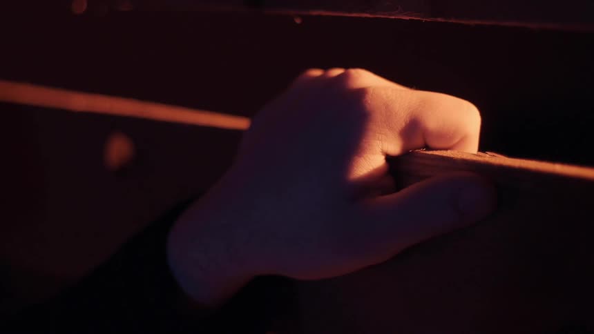 A person tapping a piece of wood
