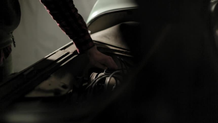 Man tightening a bolt on a car with a ratchet