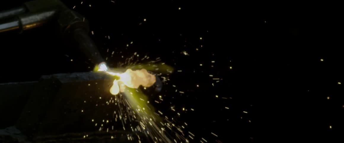 Sparks fly from a heated piece of metal