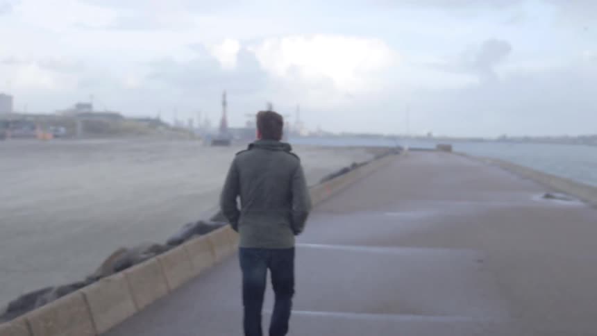 A person walking past some windmills