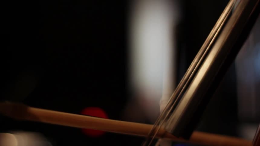 Person playing the cello in a dim room
