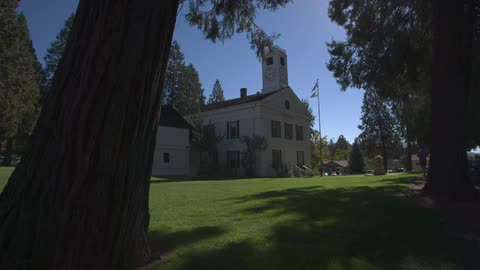 A flag flies in front of a white building