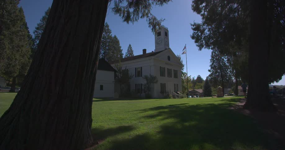 A flag flies in front of a white building