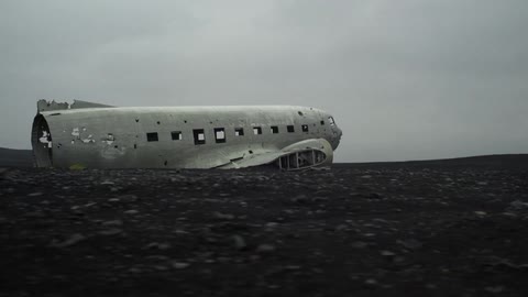 An old, dilapidated airplane sits in the middle of a field