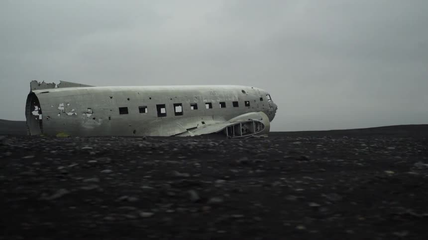 An old, dilapidated airplane sits in the middle of a field