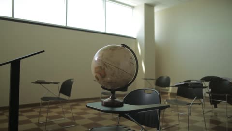 A globe spins inside a classroom