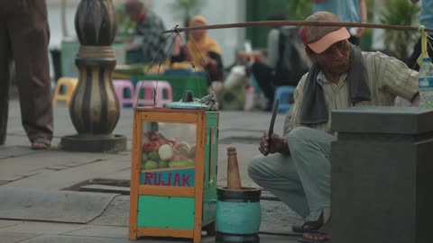 A man places fruit into a mortar and pestle